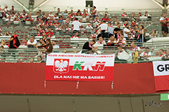 Kibice na trybunach, widoczna flaga biało-czerwona z napisem KKN