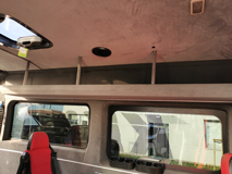 Wnętrze busa, z lewej strony przy suficie półka na całej długości, pod półką szyba